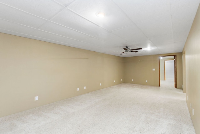 carpeted spare room with a drop ceiling and ceiling fan