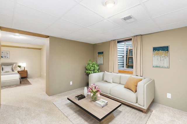 carpeted living room featuring a drop ceiling