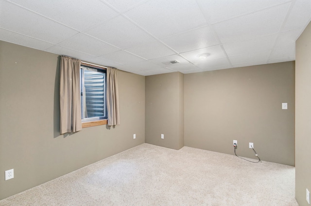 carpeted empty room featuring a paneled ceiling