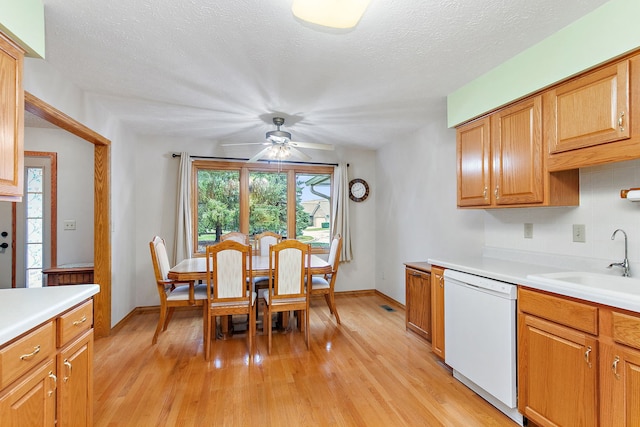 kitchen with light wood-type flooring, a textured ceiling, ceiling fan, sink, and dishwasher