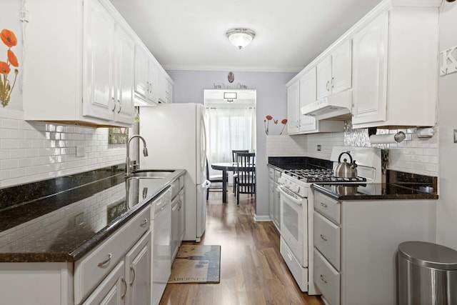 kitchen with dark hardwood / wood-style flooring, dark stone counters, white appliances, crown molding, and white cabinetry