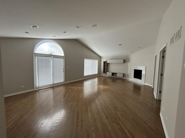 unfurnished living room with lofted ceiling and dark hardwood / wood-style floors