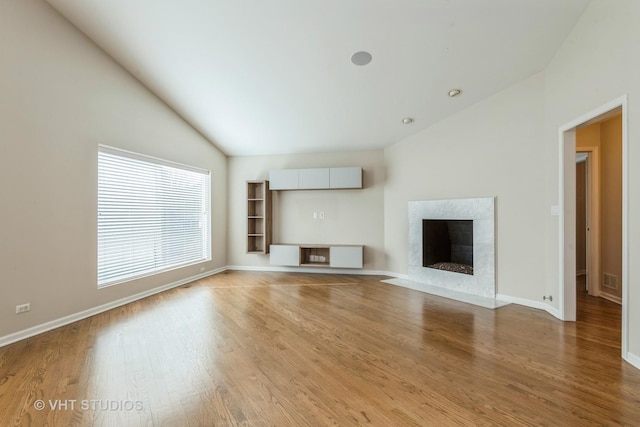 unfurnished living room with hardwood / wood-style flooring, a fireplace, and vaulted ceiling