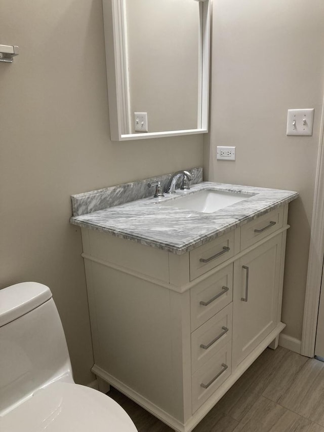 bathroom featuring vanity and toilet