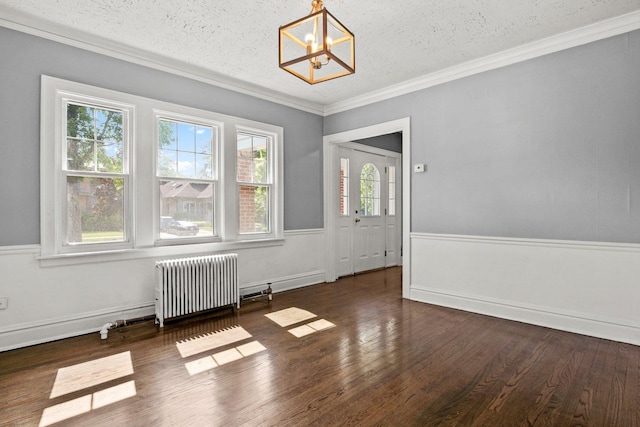 unfurnished dining area with a healthy amount of sunlight, dark hardwood / wood-style flooring, a notable chandelier, and radiator