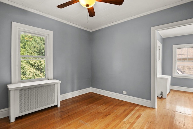 unfurnished room featuring ornamental molding, ceiling fan, light hardwood / wood-style flooring, and radiator