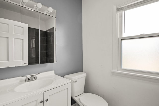 bathroom featuring toilet, vanity, and plenty of natural light