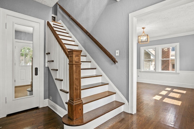 stairway with a notable chandelier, a textured ceiling, and wood-type flooring