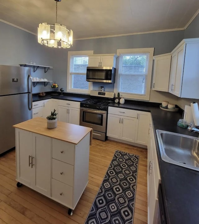 kitchen featuring sink, white cabinets, a center island, and stainless steel appliances