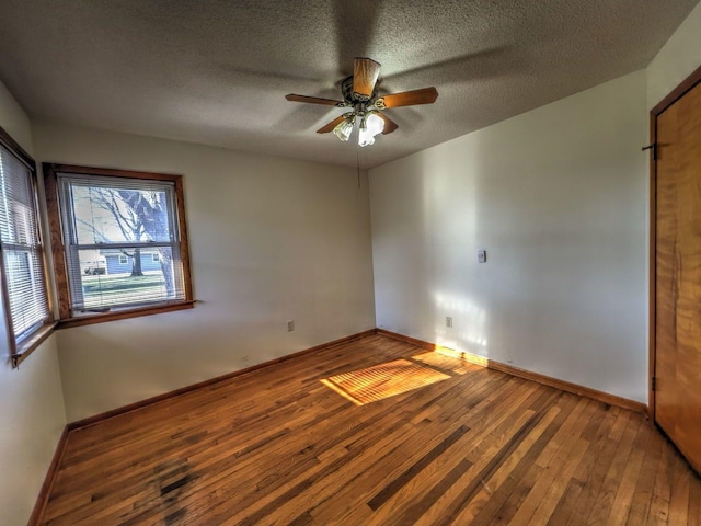 unfurnished room featuring ceiling fan, wood-type flooring, and a textured ceiling