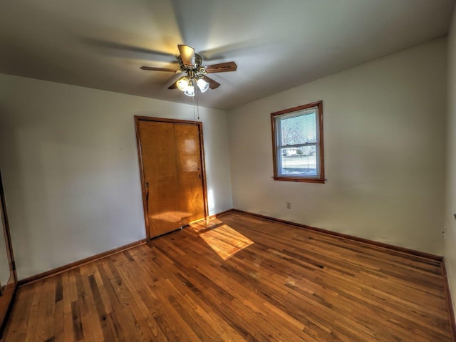 unfurnished bedroom with a closet, ceiling fan, and hardwood / wood-style flooring