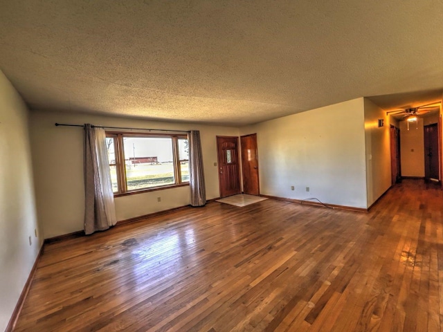 spare room featuring dark wood-type flooring and a textured ceiling