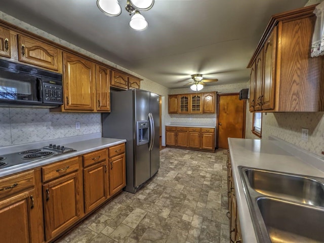 kitchen with backsplash, stainless steel appliances, ceiling fan, and sink