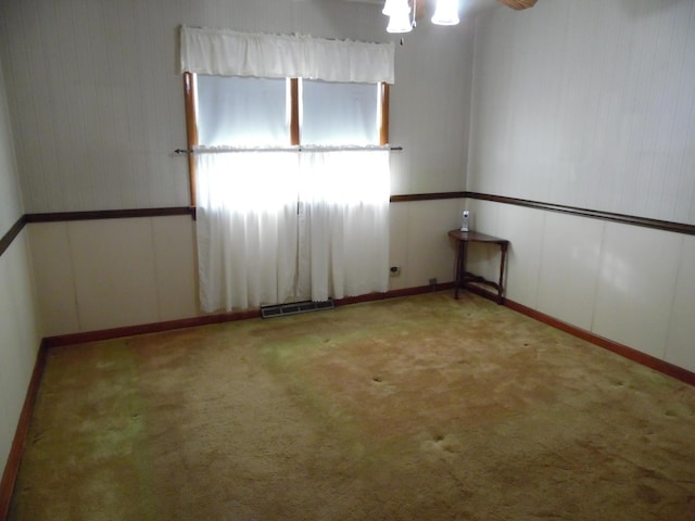 carpeted spare room featuring ceiling fan