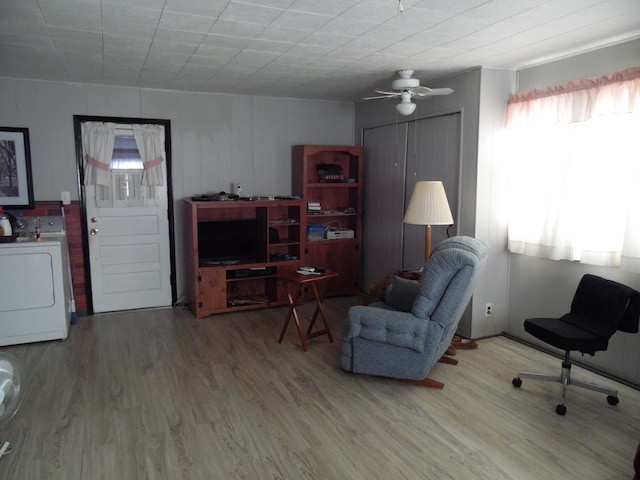 living room with washer / dryer, plenty of natural light, and hardwood / wood-style flooring