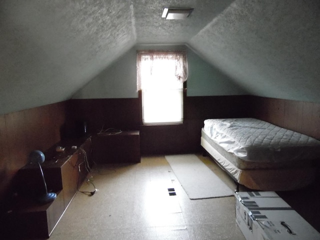 bedroom with a textured ceiling and lofted ceiling