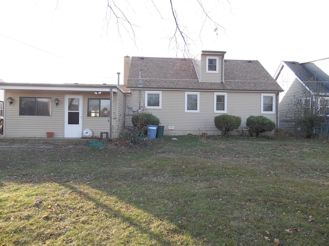 rear view of property with a yard