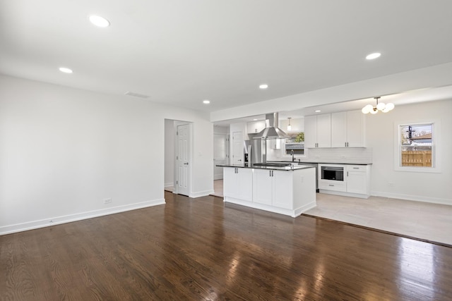 kitchen with white cabinets, hardwood / wood-style floors, and a center island