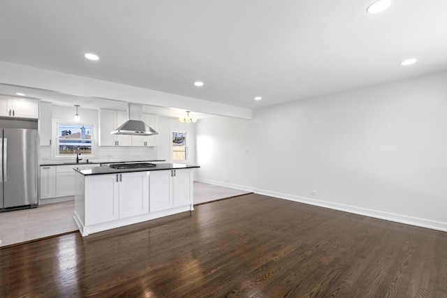 kitchen featuring white cabinetry, stainless steel fridge, wall chimney exhaust hood, and dark hardwood / wood-style floors