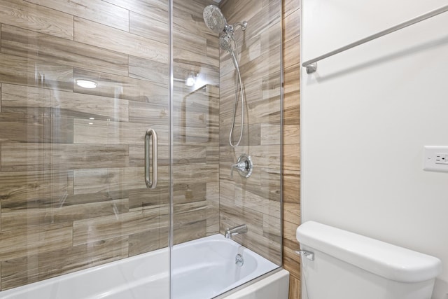 bathroom with toilet and combined bath / shower with glass door