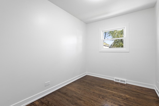 empty room with dark hardwood / wood-style flooring