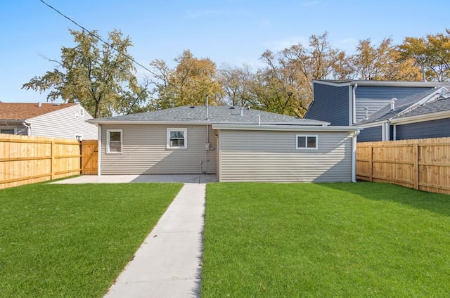 rear view of house featuring a yard and a patio