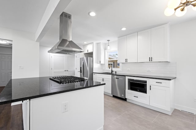 kitchen with stainless steel appliances, white cabinetry, sink, and extractor fan