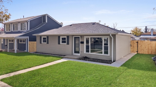 rear view of property featuring a lawn