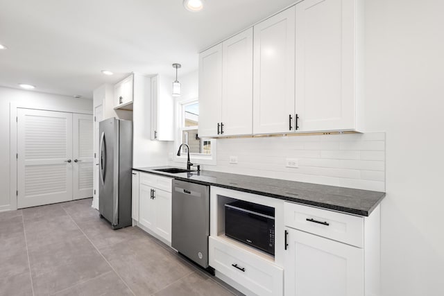 kitchen with sink, hanging light fixtures, tasteful backsplash, white cabinetry, and stainless steel appliances