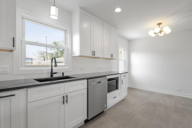 kitchen featuring dishwasher, white cabinets, hanging light fixtures, and sink