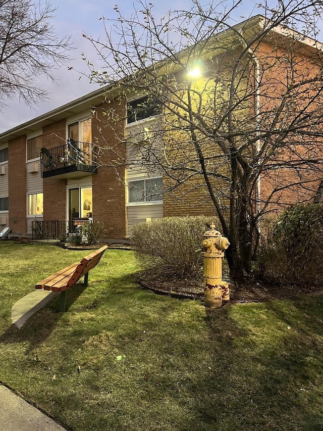 exterior space featuring a balcony and a lawn