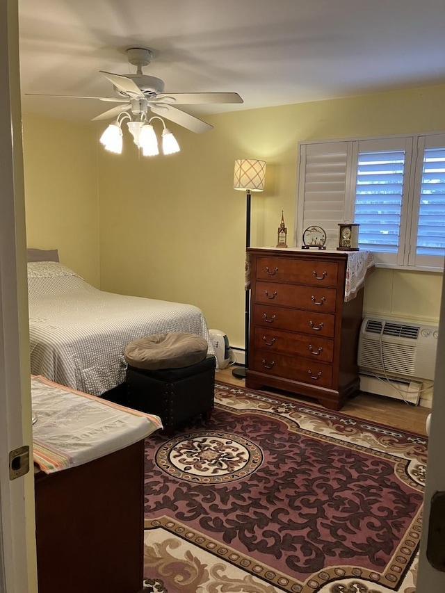 bedroom featuring a wall unit AC, ceiling fan, and a baseboard heating unit