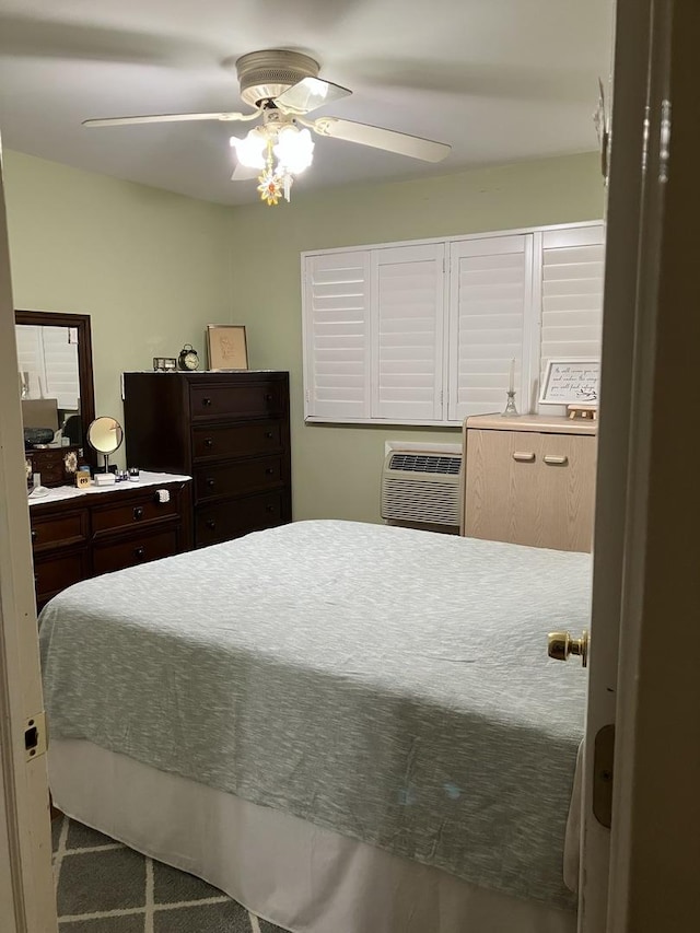 bedroom with a wall unit AC and ceiling fan