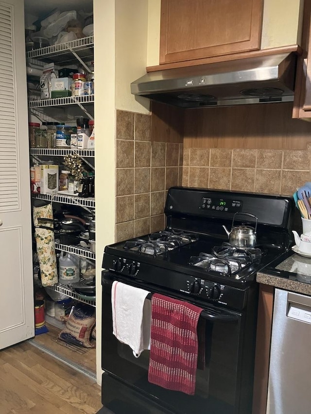 kitchen with black gas stove, tasteful backsplash, stainless steel dishwasher, and wood-type flooring