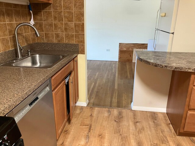 kitchen with dishwasher, decorative backsplash, white gas range, and sink