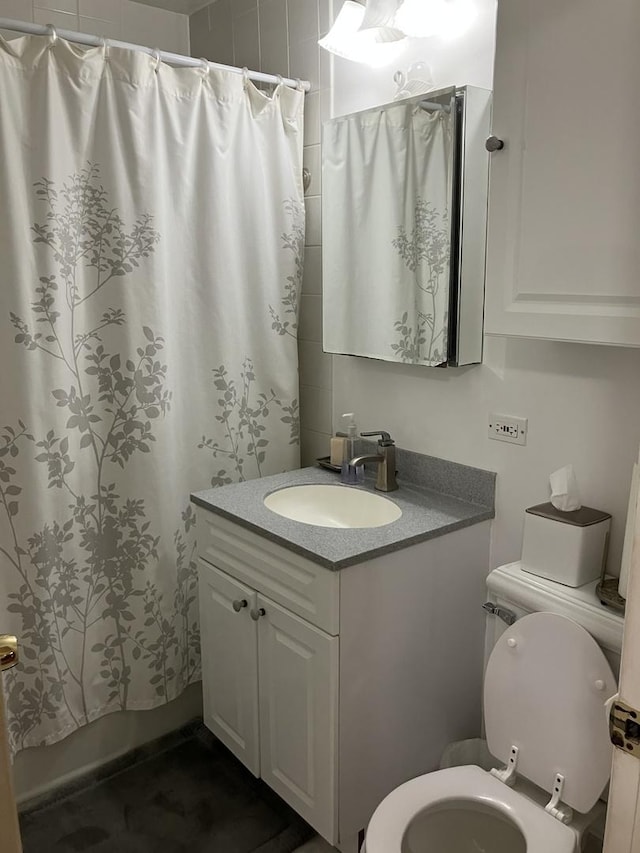 full bathroom featuring toilet, a shower with shower curtain, and vanity