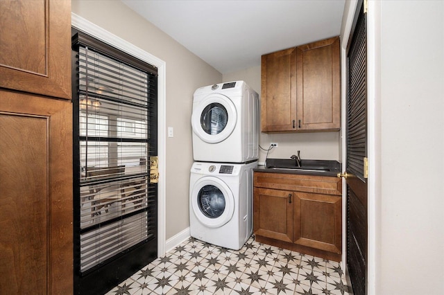 laundry area featuring sink, cabinets, and stacked washer / drying machine