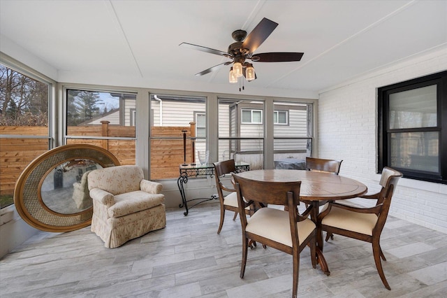 sunroom featuring ceiling fan and plenty of natural light