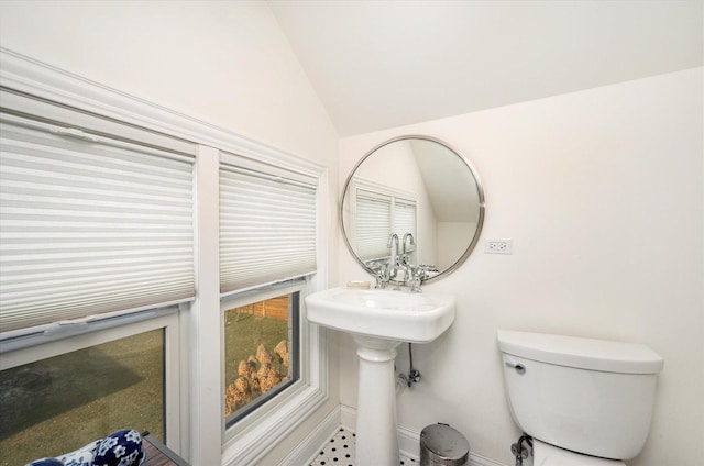 bathroom with toilet and lofted ceiling