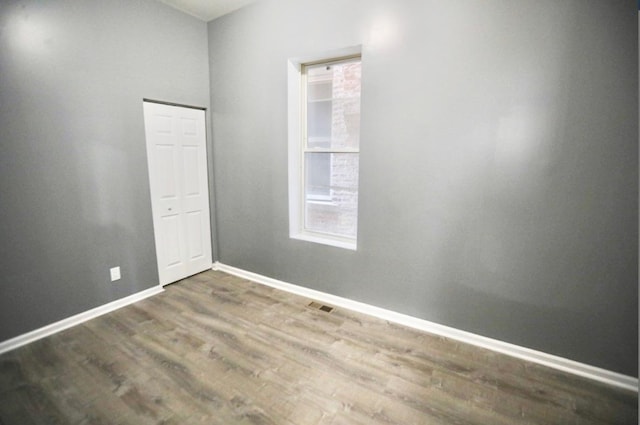 empty room with dark hardwood / wood-style flooring