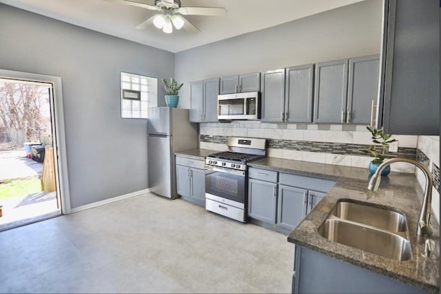 kitchen featuring ceiling fan, sink, backsplash, dark stone counters, and appliances with stainless steel finishes