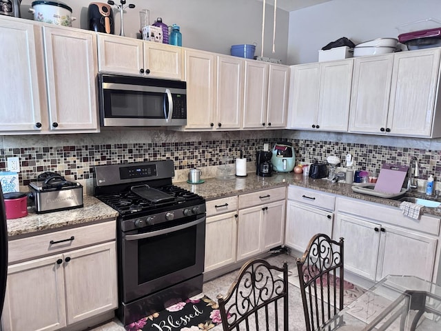 kitchen featuring dark stone countertops, stainless steel appliances, and tasteful backsplash