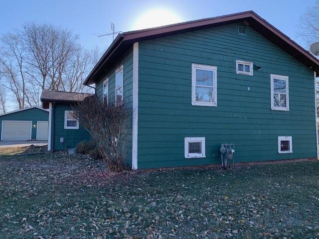 view of home's exterior with a yard, an outdoor structure, and a garage