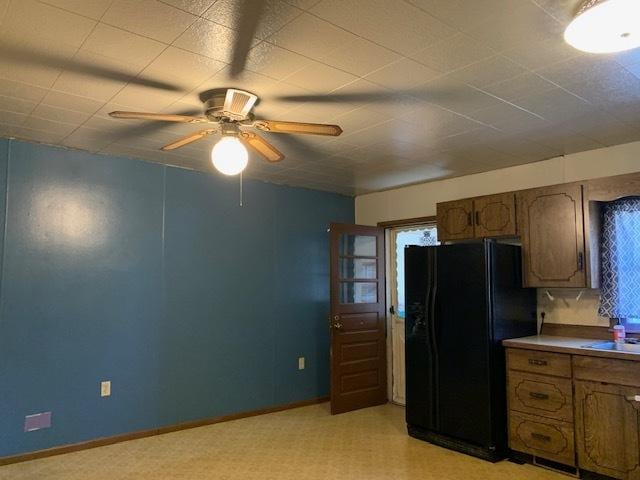 kitchen featuring ceiling fan, black fridge with ice dispenser, and sink