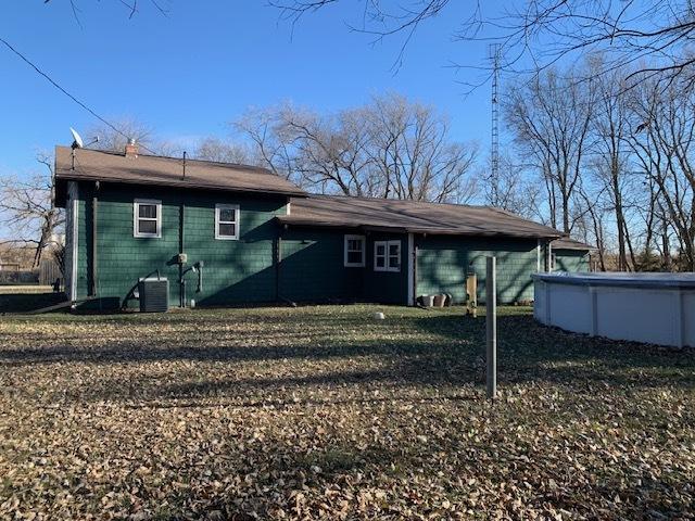 back of house with a yard and central AC