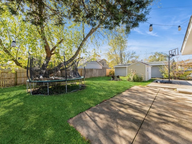 view of yard featuring an outdoor structure, a trampoline, and a patio area