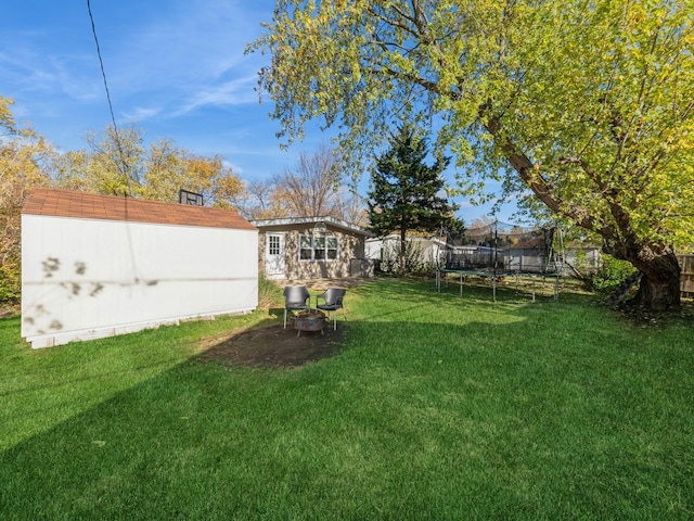 view of yard featuring a storage shed and a trampoline