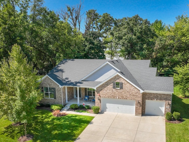 view of front of home featuring a front yard, a garage, and a porch