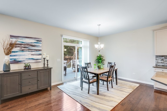 dining area with an inviting chandelier and dark hardwood / wood-style floors