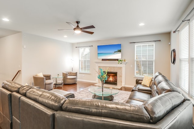 living room featuring a tile fireplace, ceiling fan, and hardwood / wood-style floors